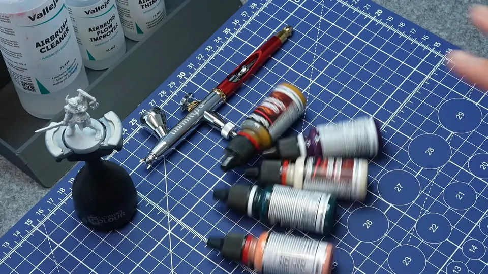 Airbrush, thinner and a row of paints laid out on the cutting mat, Episode 04